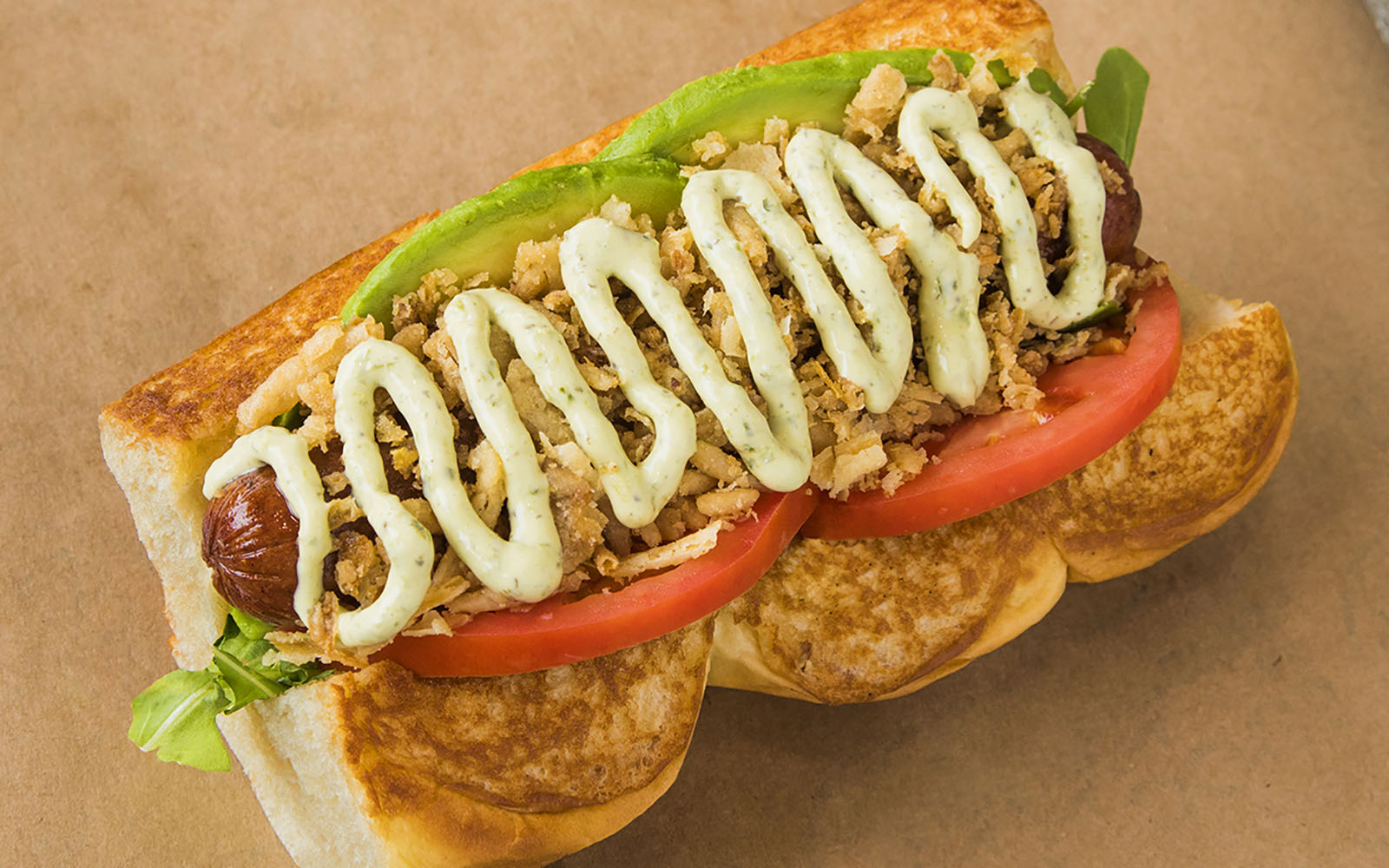 Dog Haus’s Sooo Cali: a hot dog topped with arugula, avocado, tomato, crispy onions and spicy basil aioli