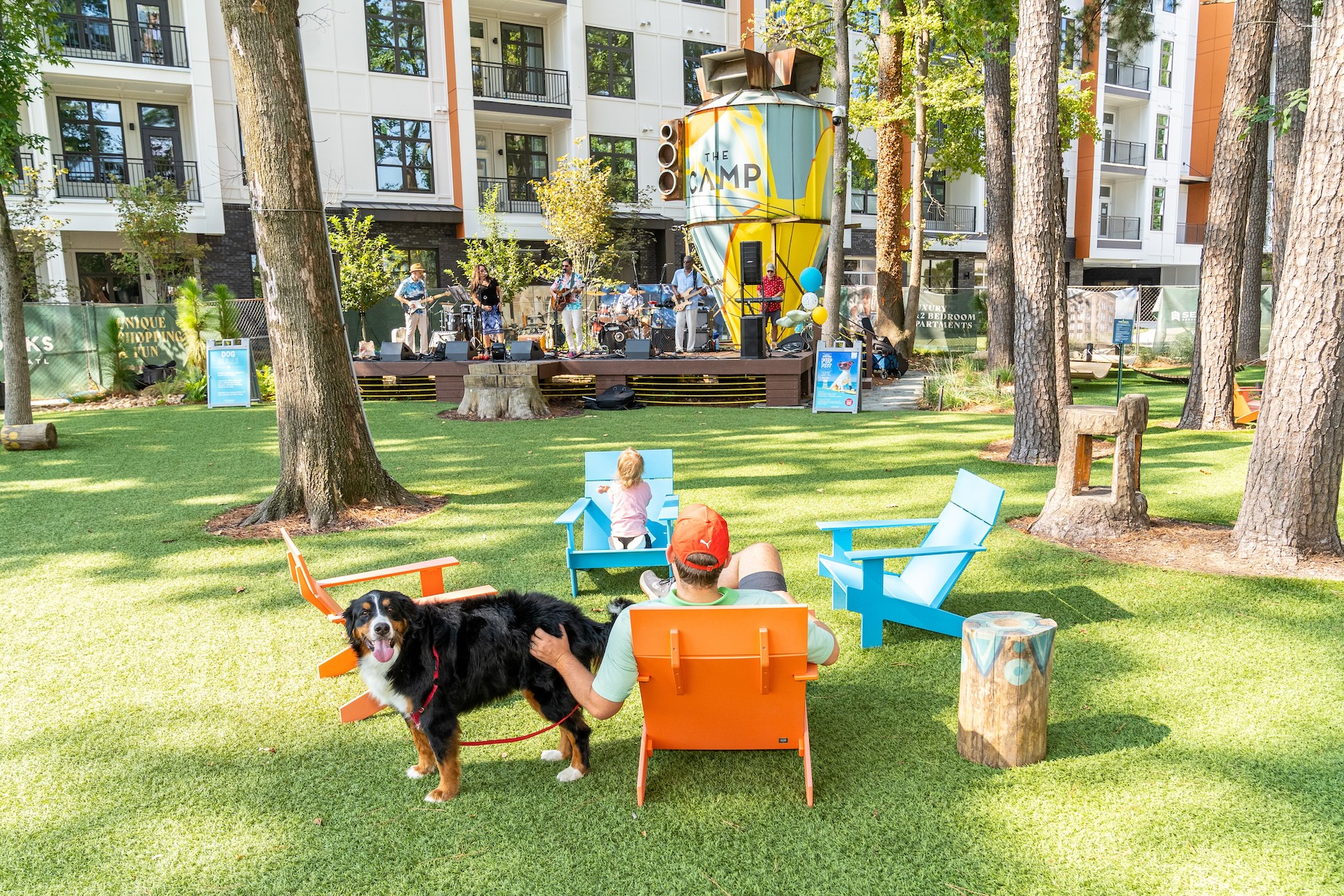 A dog and his people enjoy a band at The Camp, a central park at The Works mixed-use community in Atlanta’s Upper Westside.