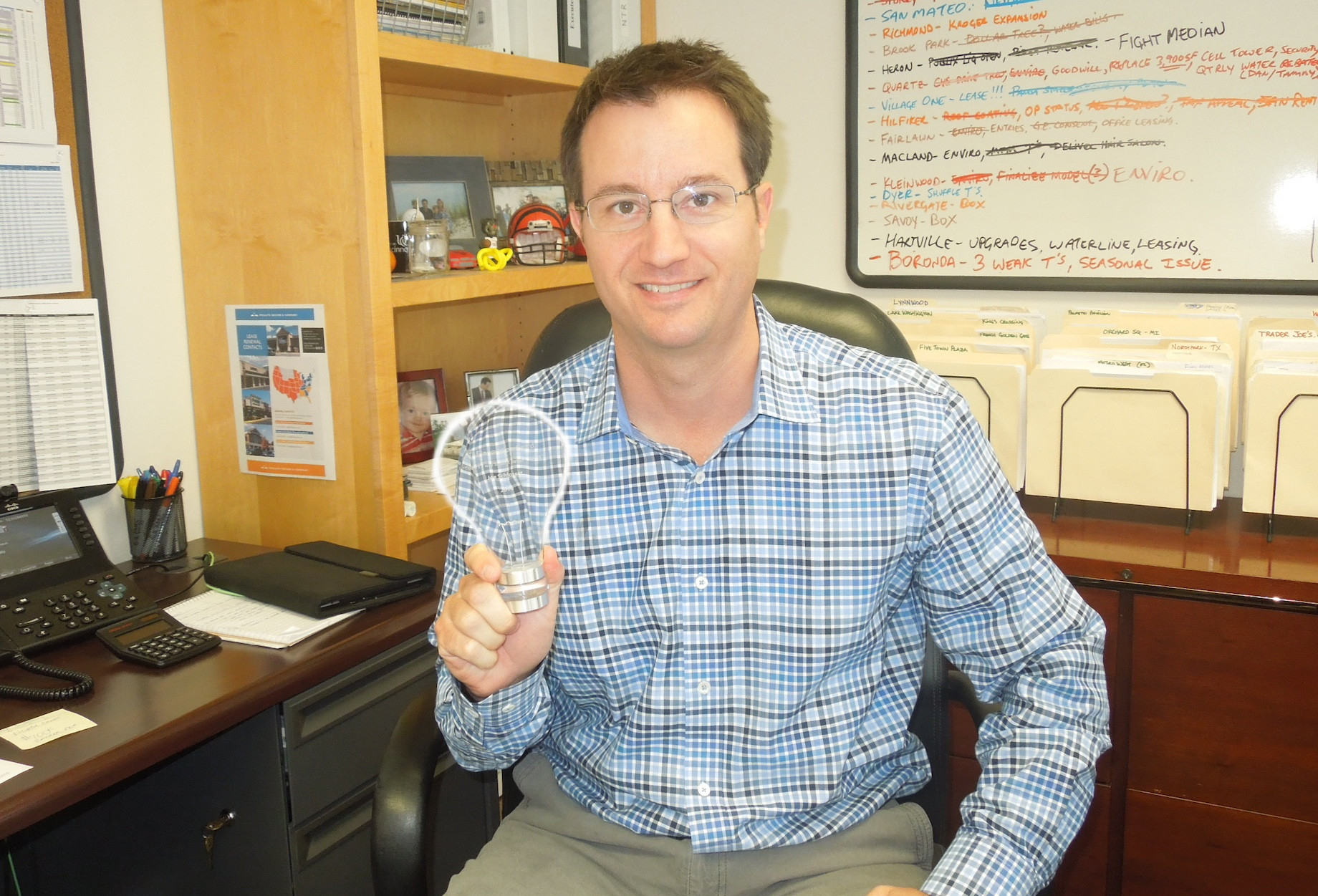 Joe Schlosser, a fan of both numbers and creativity, displays his Phillips Edison & Co. Innovation Award in 2014. The hon