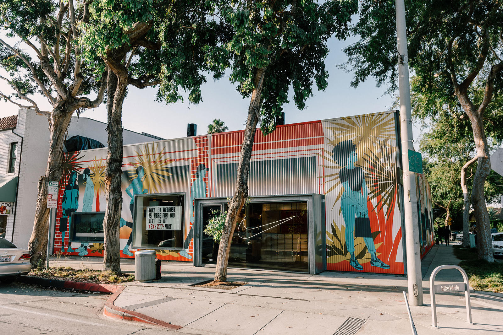 The store's facade showcases Angelenos shopping against the backdrop of a classic SoCal sunset. Artist-illustrator Bijou