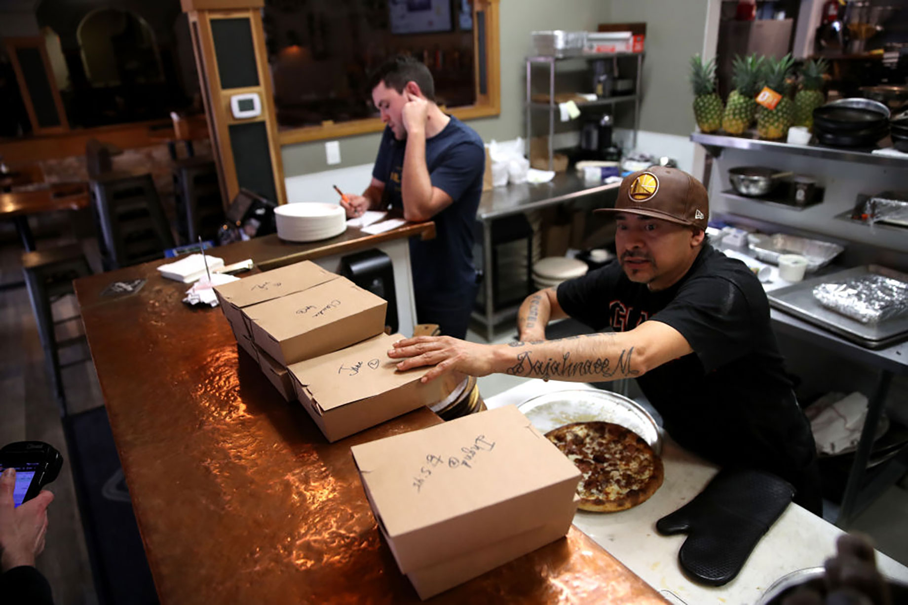 A worker prepares to-go orders at Creekside Pizza & Taproom, in San Anselmo, California