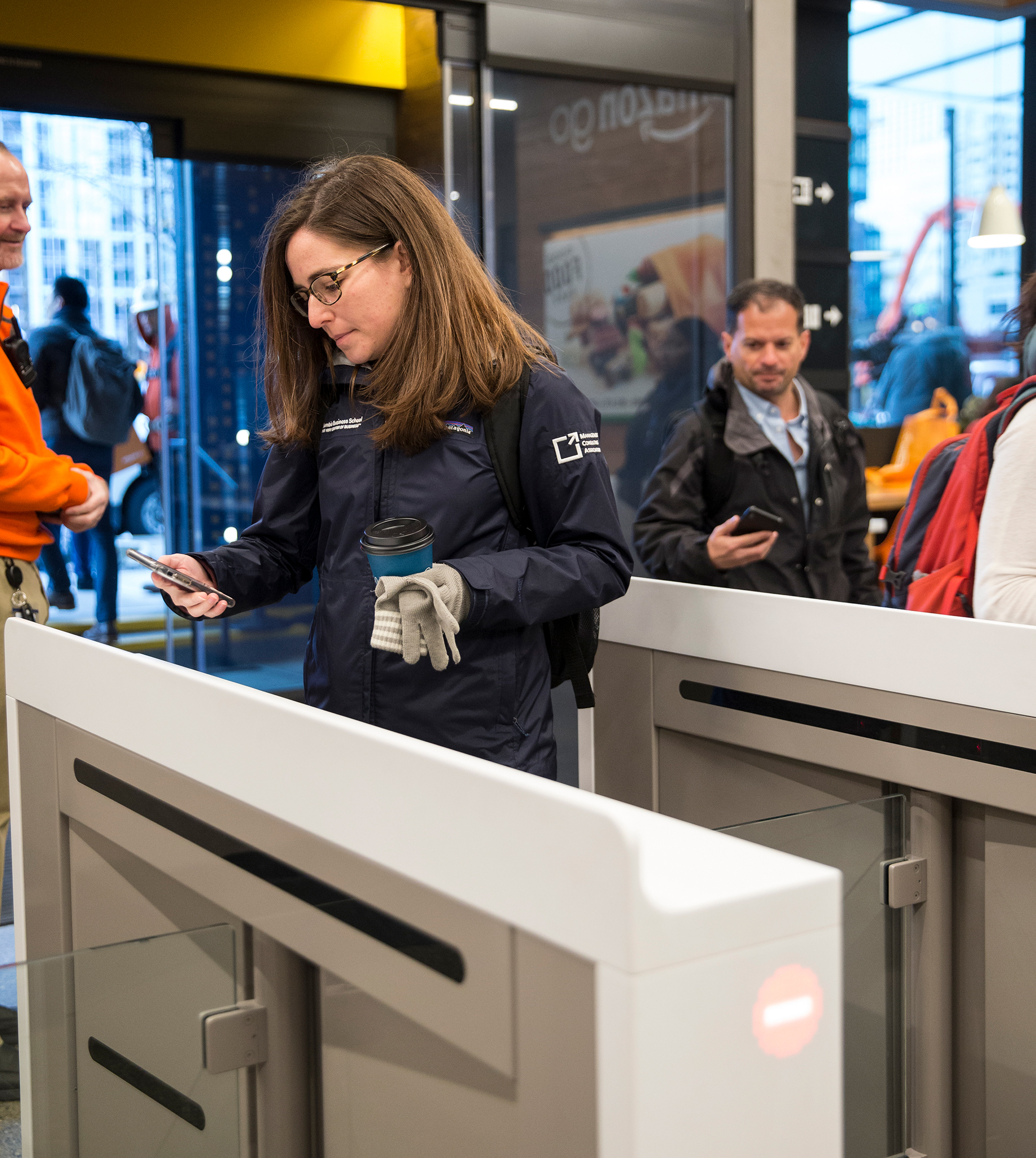 Shoppers scan the Amazon Go app on their mobile devices as they enter the Amazon Go store, in Seattle